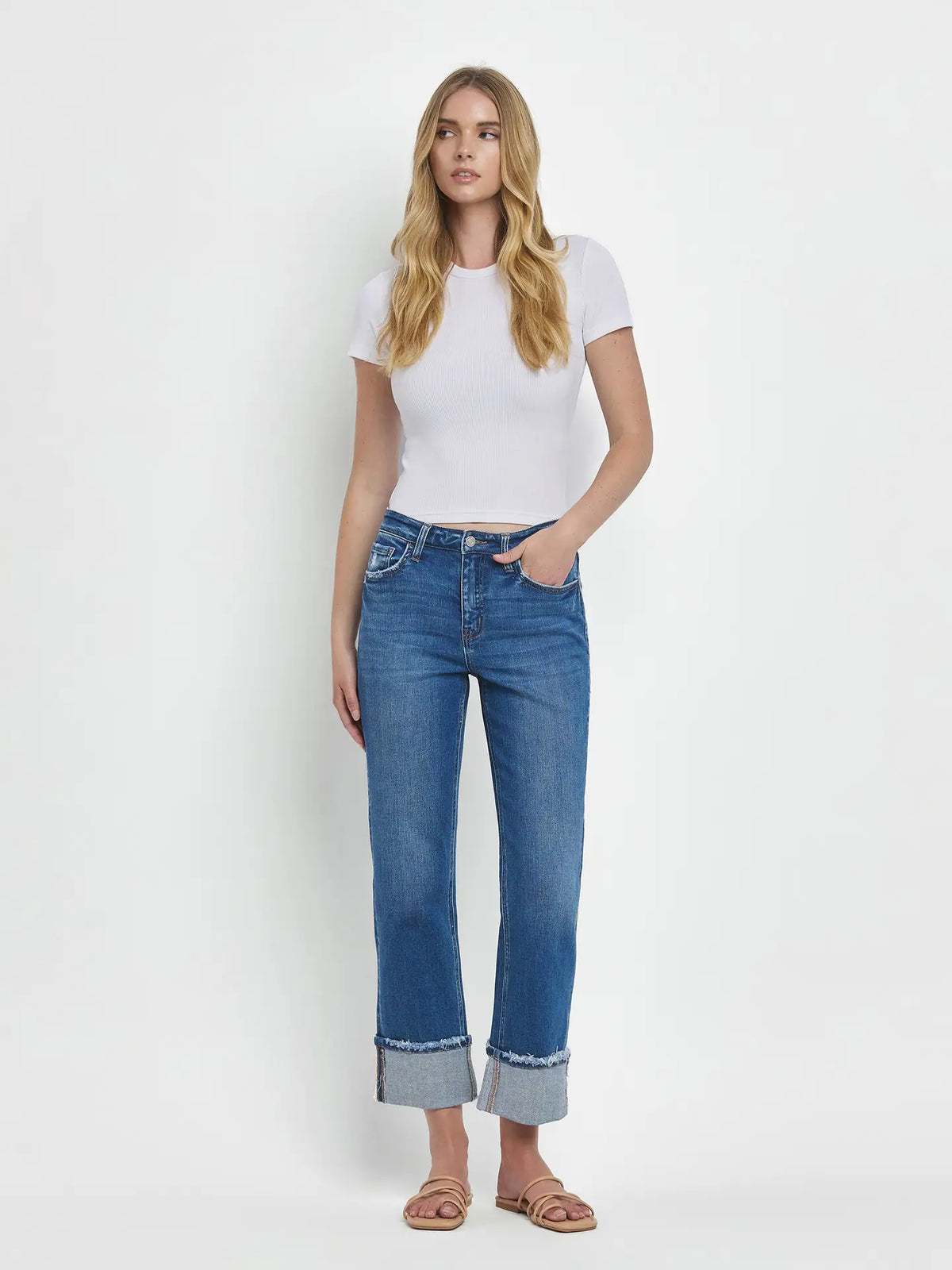 Woman wearing a white t-shirt and blue jeans on a white background