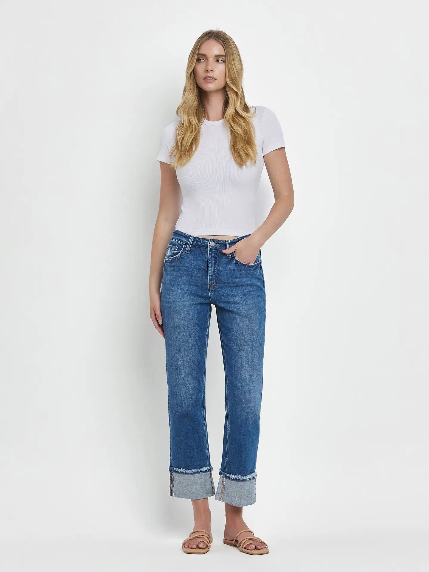 Woman wearing a white t-shirt and blue jeans on a white background