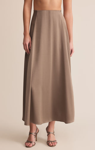 Brown maxi skirt worn by a person on a beige background