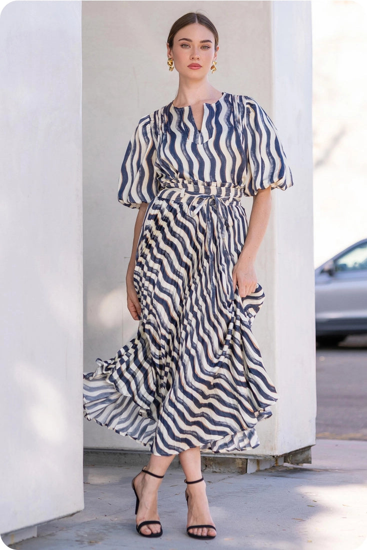 Woman wearing a blue and white striped dress standing outdoors.