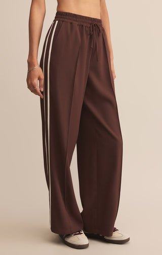 Brown wide-leg pants with a white stripe on a beige background