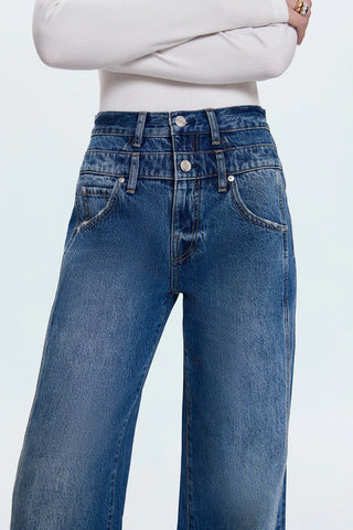 Blue jeans worn by a person on a light gray background