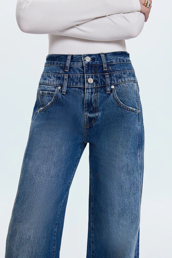 Blue jeans worn by a person on a light gray background