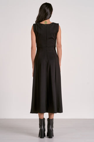 Woman wearing a black dress with a plain white background