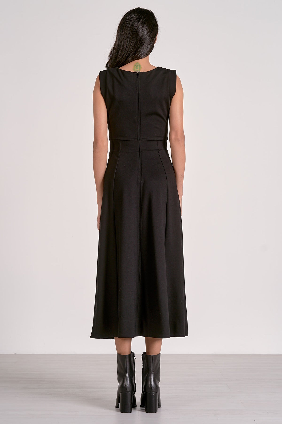 Woman wearing a black dress with a plain white background