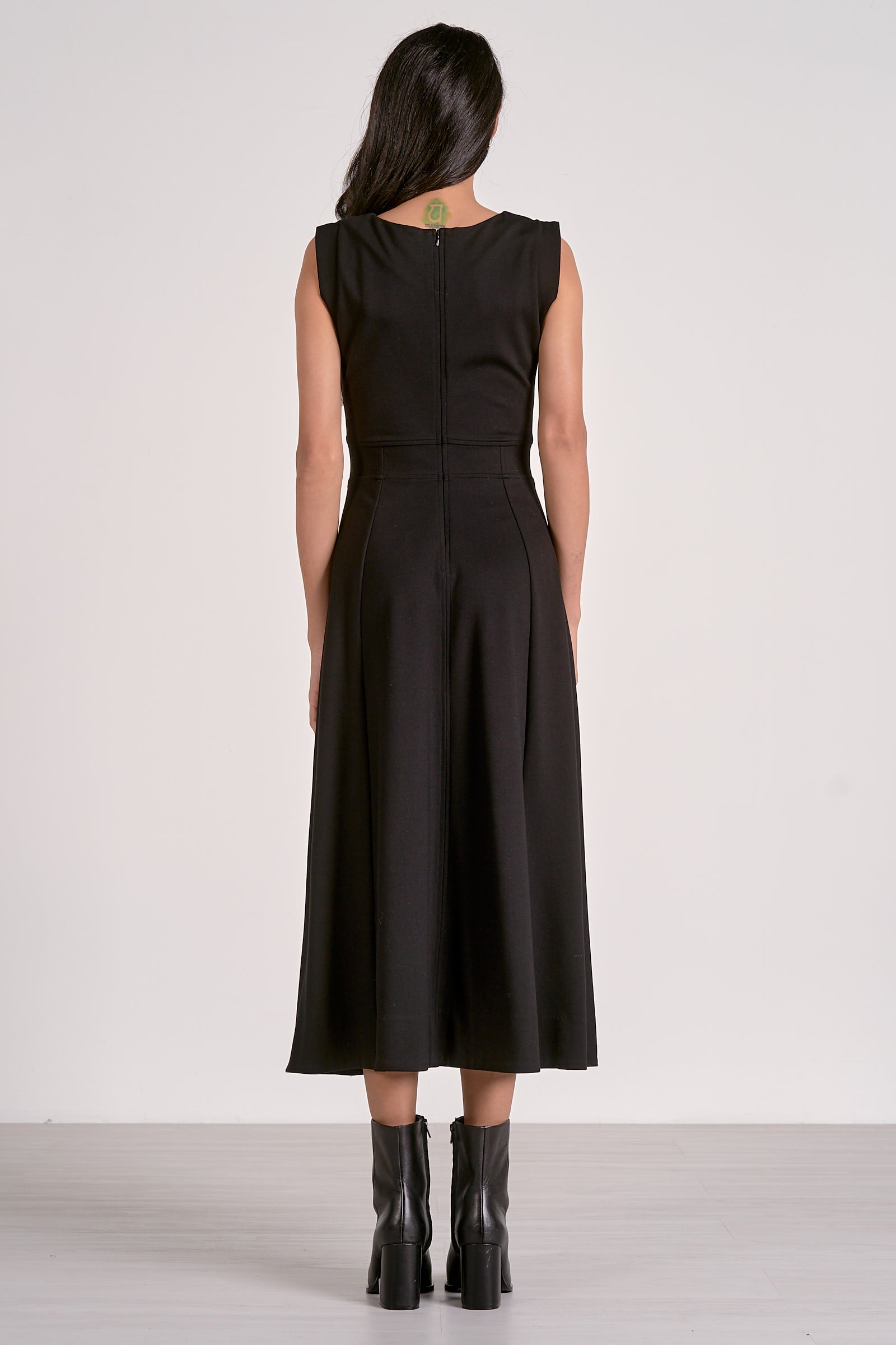 Woman wearing a black dress with black boots on a white background