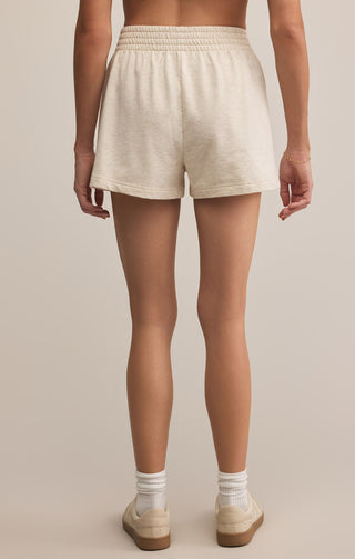 Person wearing beige shorts on a plain background