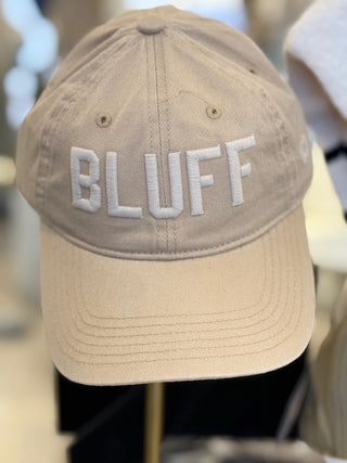 A beige cotton hat with the word 'BLUFF' embroidered in white on the front.