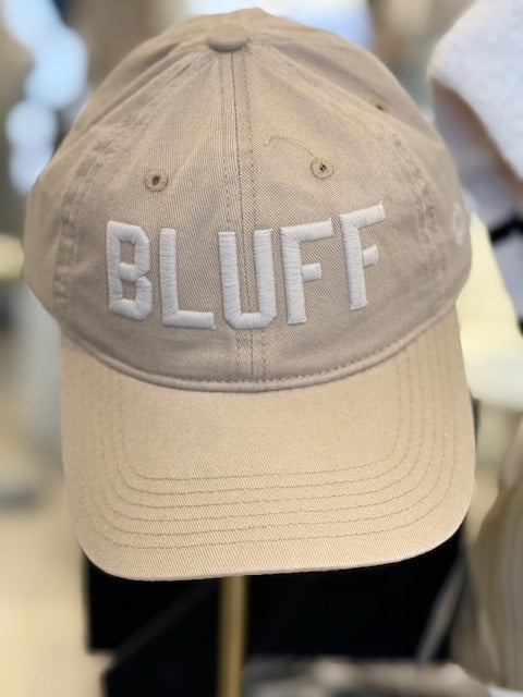 A beige cotton hat with the word 'BLUFF' embroidered in white on the front.