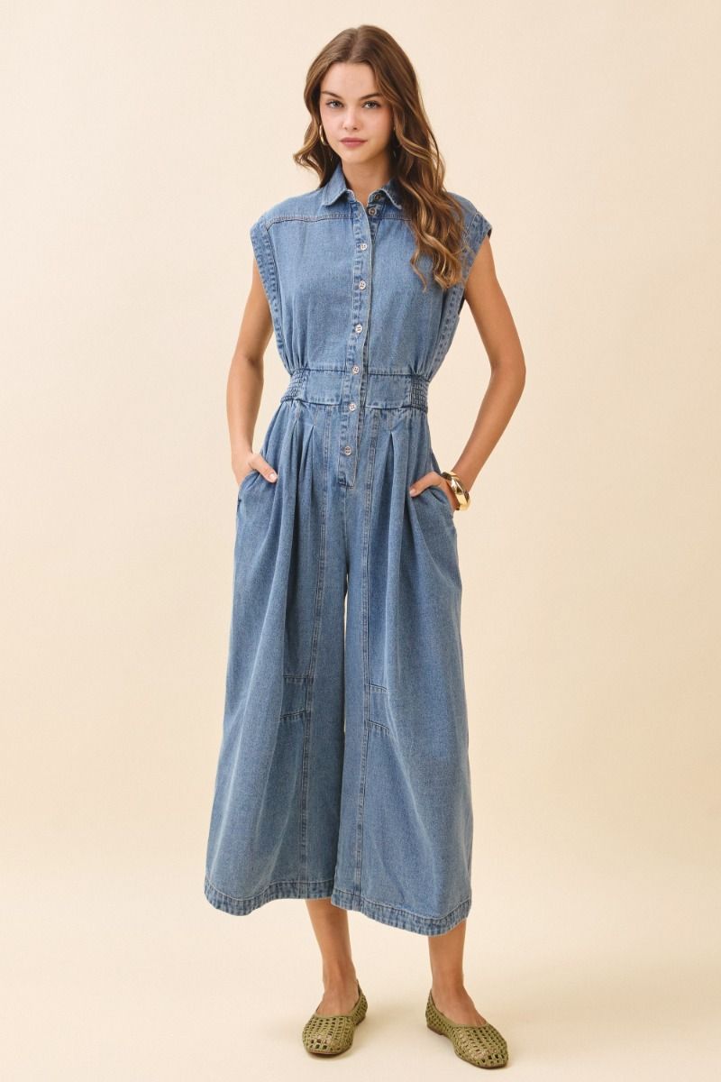 Woman wearing a denim dress against a beige background