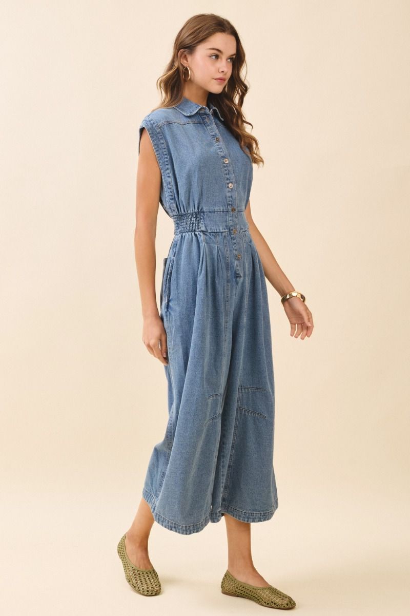 Woman wearing a denim dress on a beige background