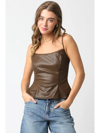 Woman wearing a brown satin camisole and blue jeans on a white background