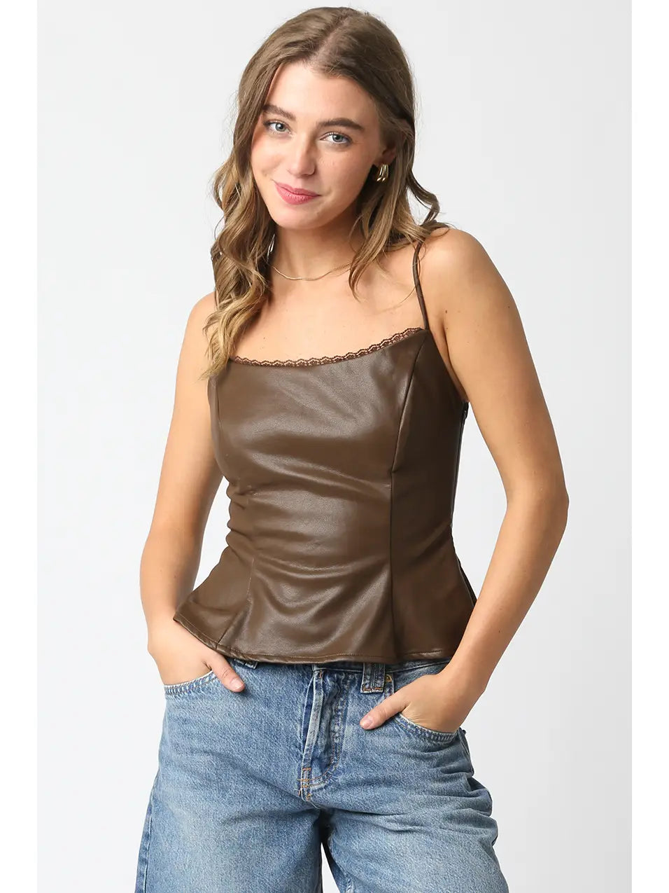 Woman wearing a brown satin camisole and blue jeans on a white background