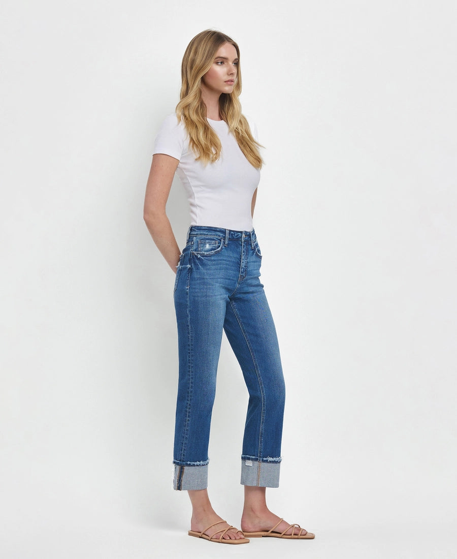 Woman wearing blue jeans and a white top on a white background