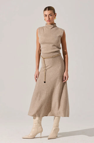 Woman wearing a beige sleeveless top and skirt with a chain belt on a white background