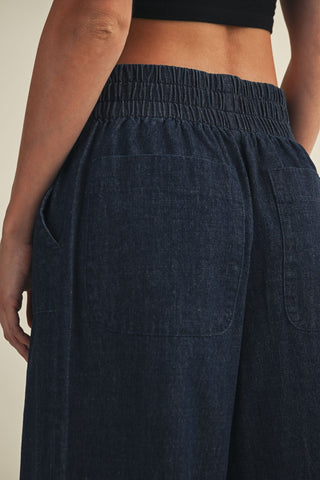 Navy blue wide-leg pants with an elastic waistband on a neutral background