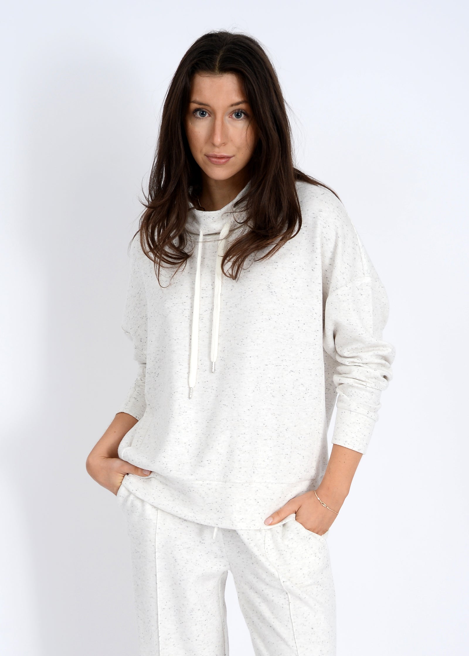 Woman wearing a white outfit against a plain background