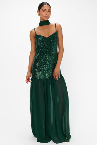Woman wearing a green sequin dress on a white background