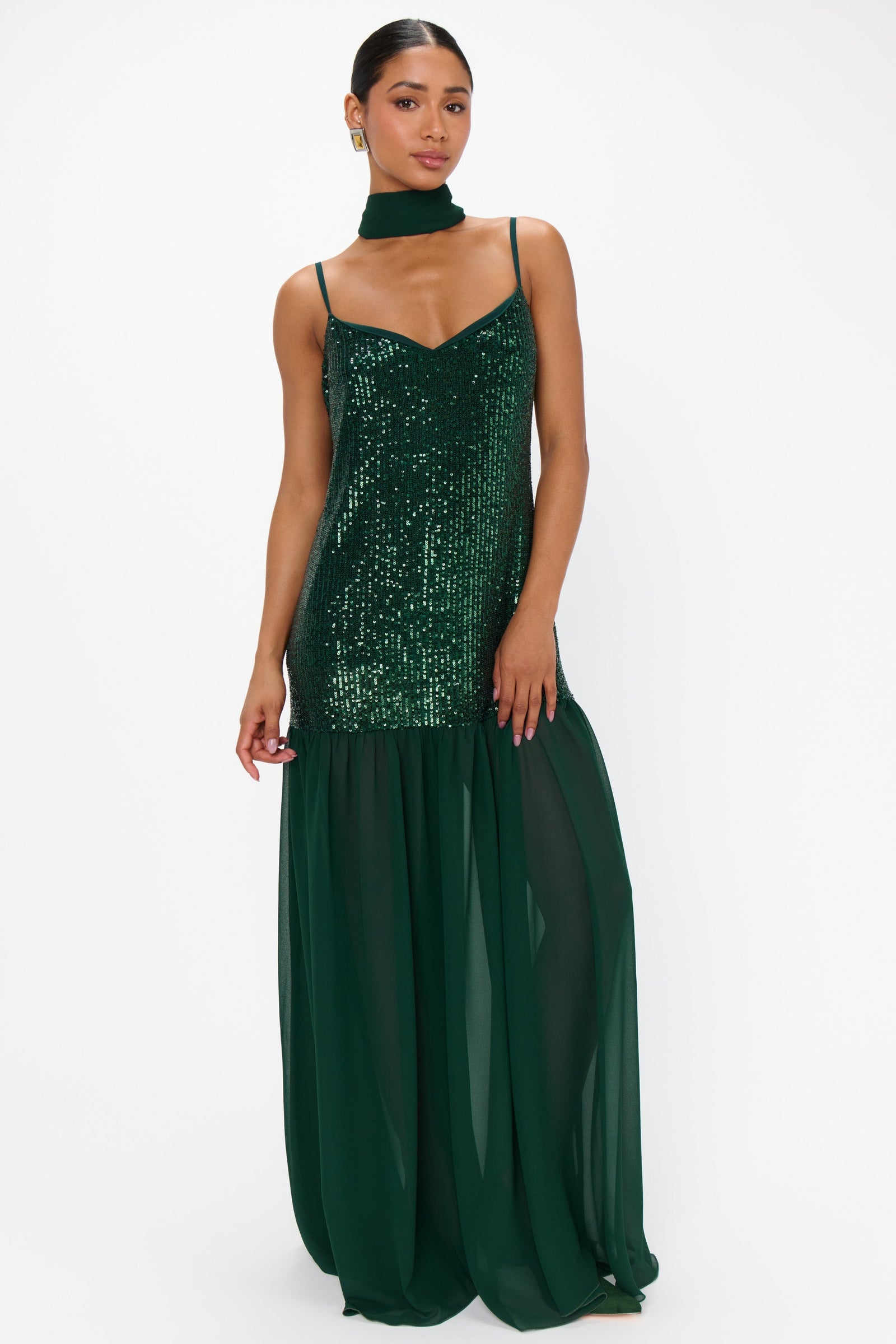 Woman wearing a green sequin dress on a white background