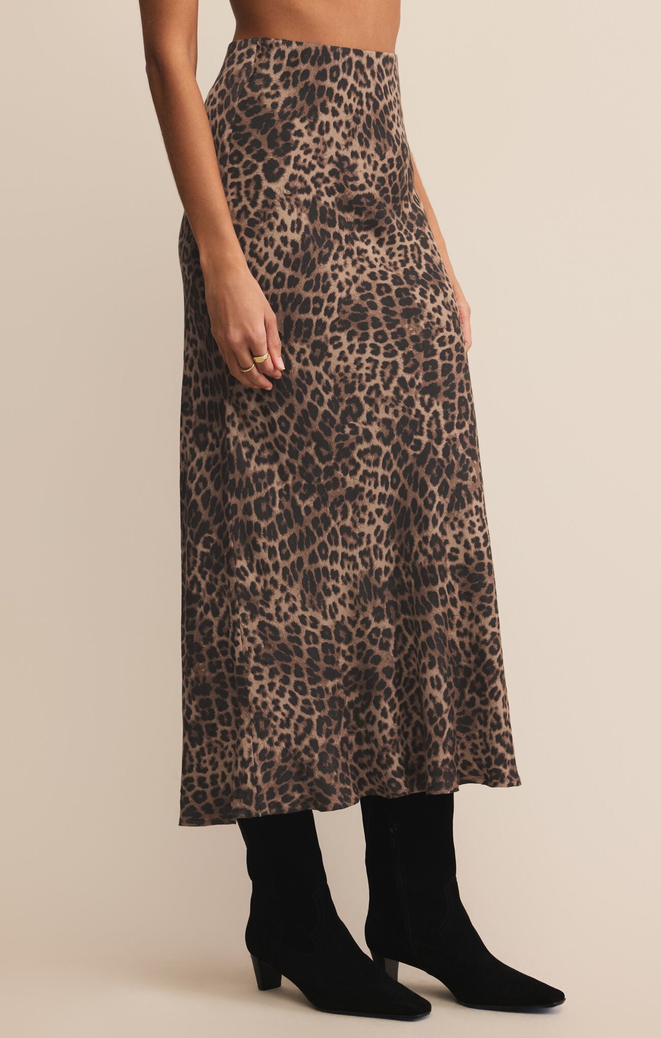 Leopard print skirt worn by a person on a beige background