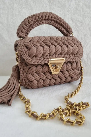 Brown braided handbag with a gold chain on a white background