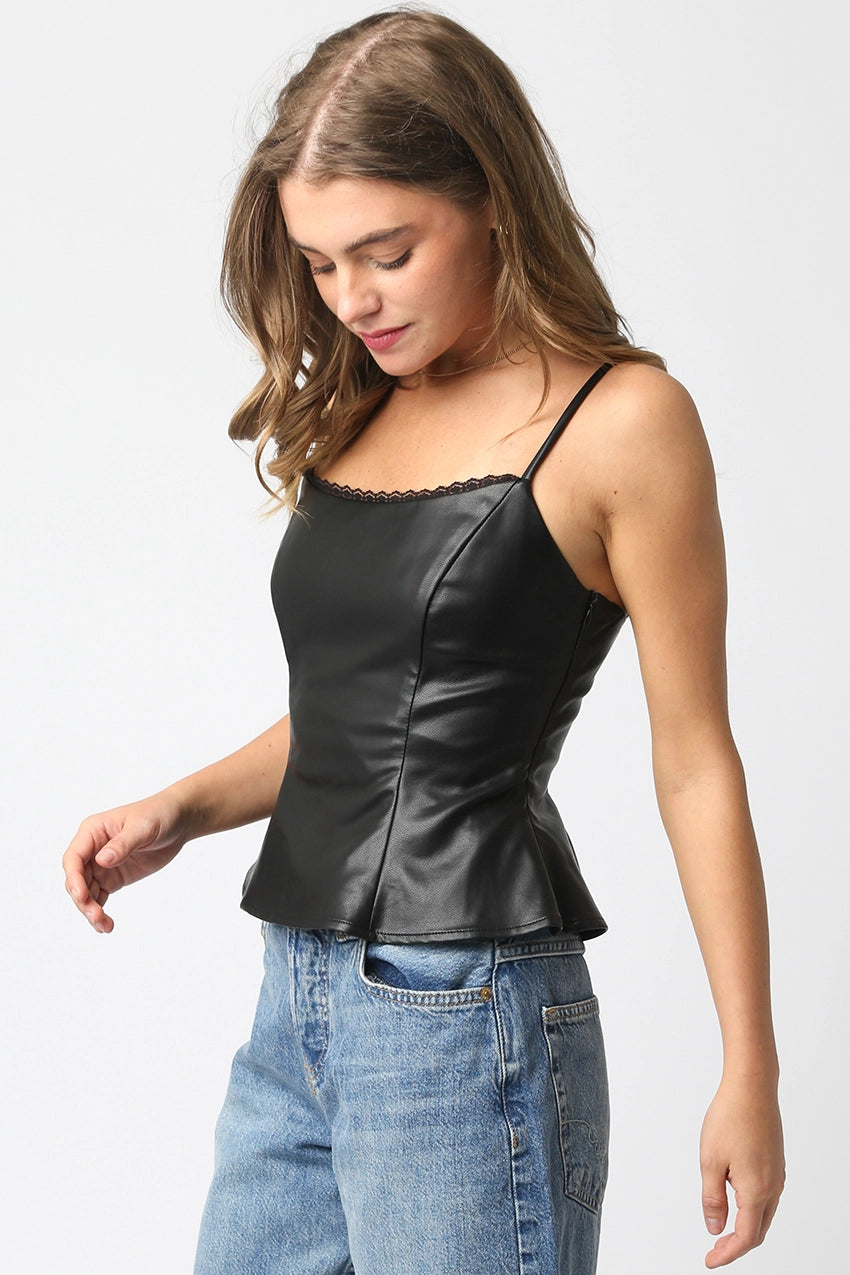 Woman wearing a black leather top and blue jeans on a white background