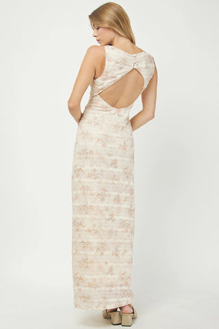 Woman wearing a long, light-colored dress with an open back on a white background