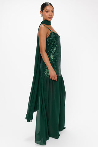 Woman wearing a green sequin dress on a white background