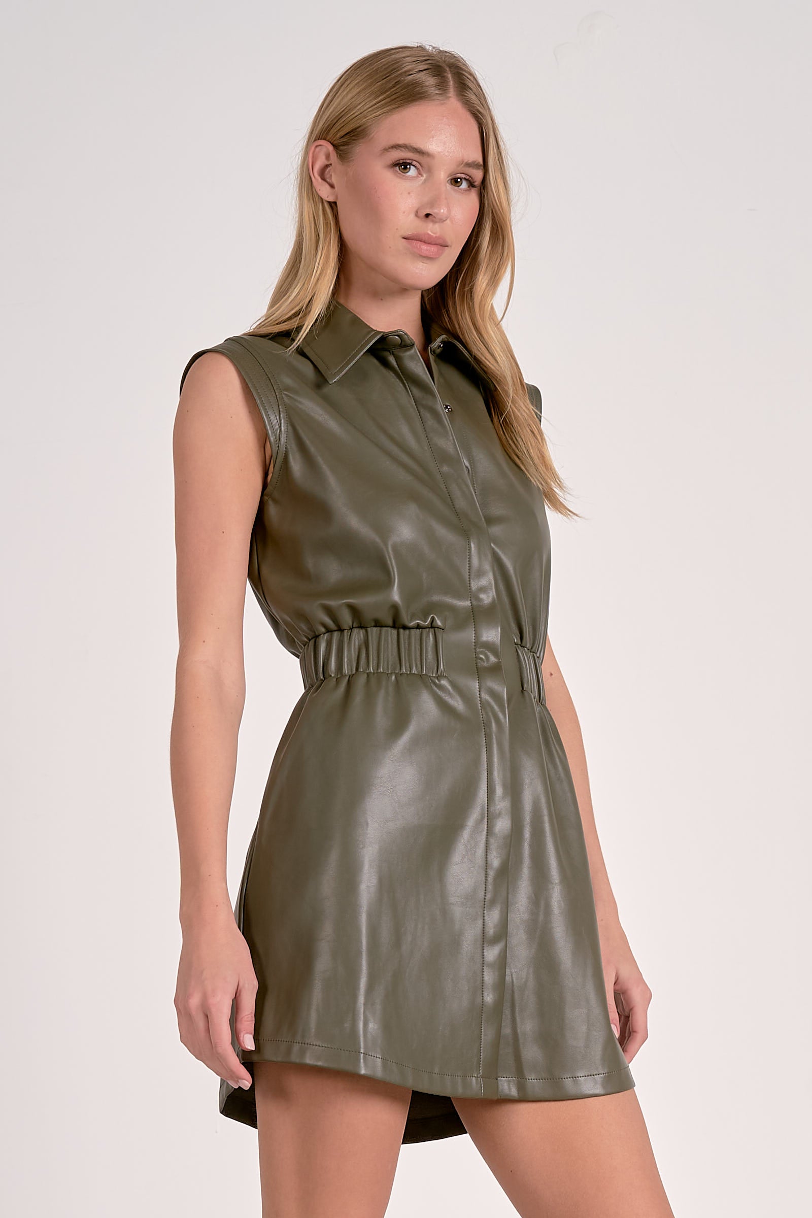 Woman wearing a green leather dress against a white background