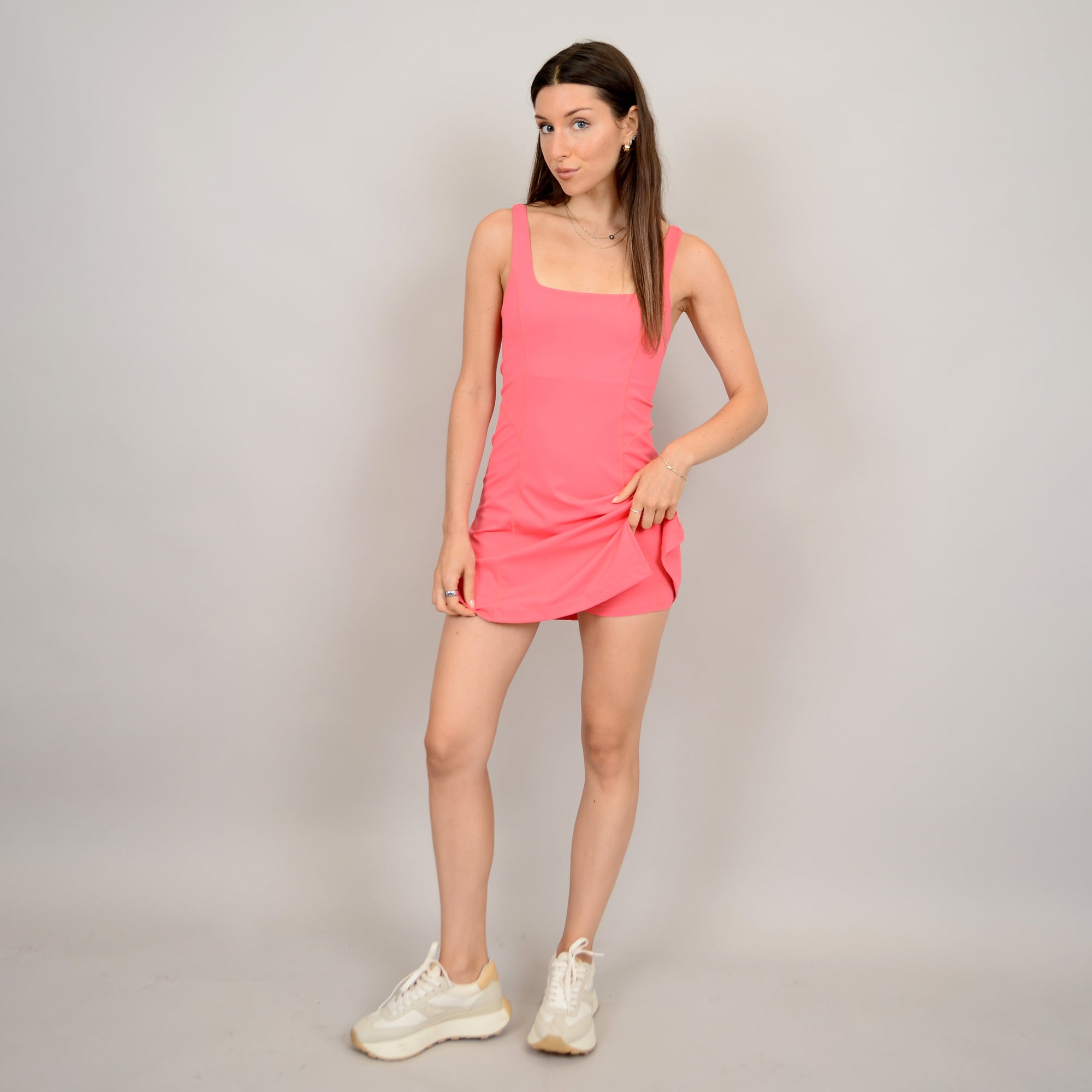 A person wearing a pink sleeveless dress STMT BOUTIQUE 