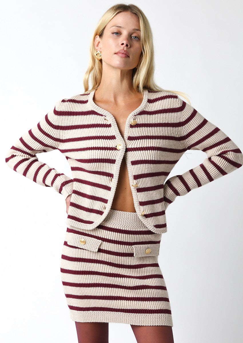 Woman wearing a striped knit outfit on a white background
