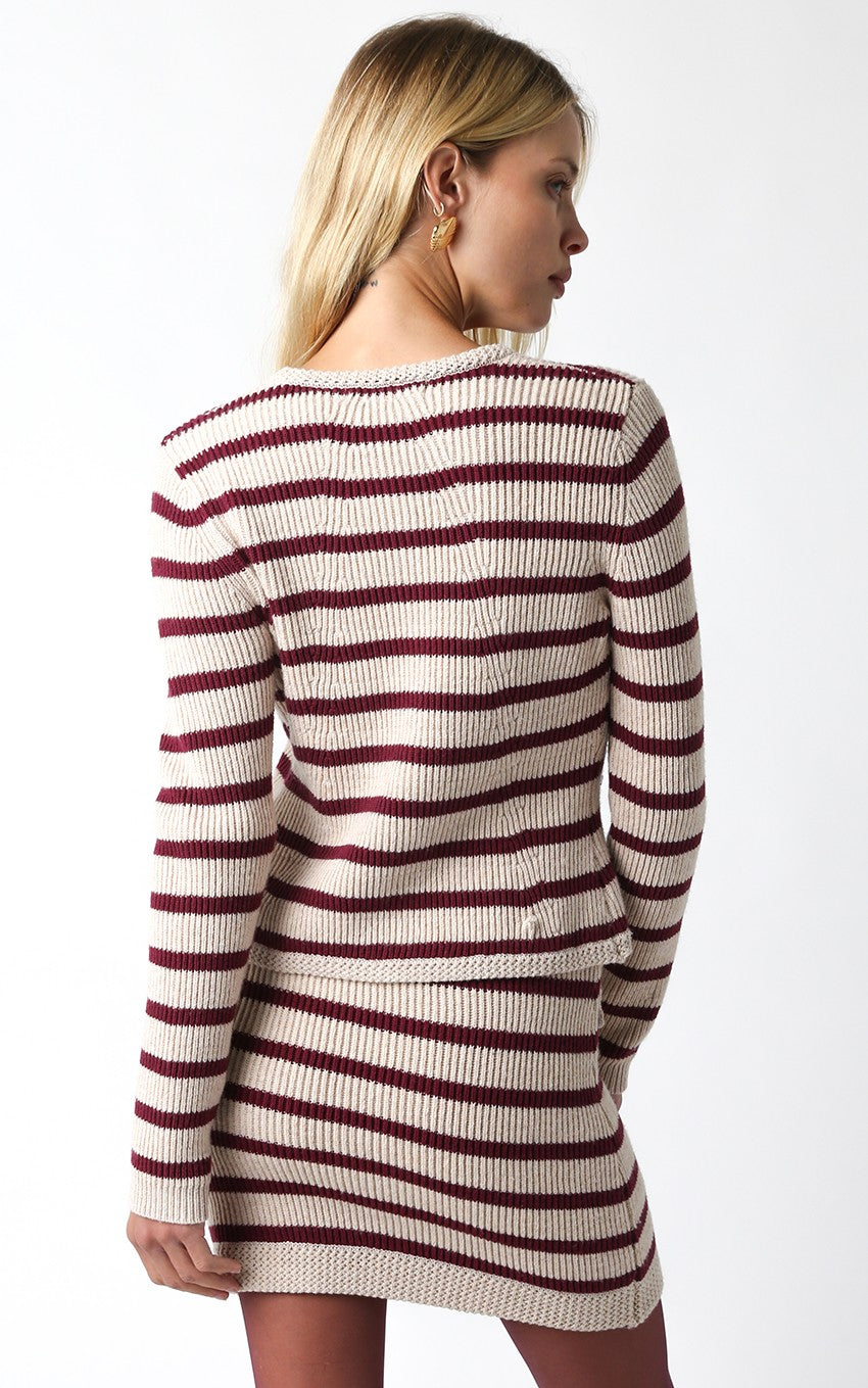 Woman wearing a striped sweater dress on a white background