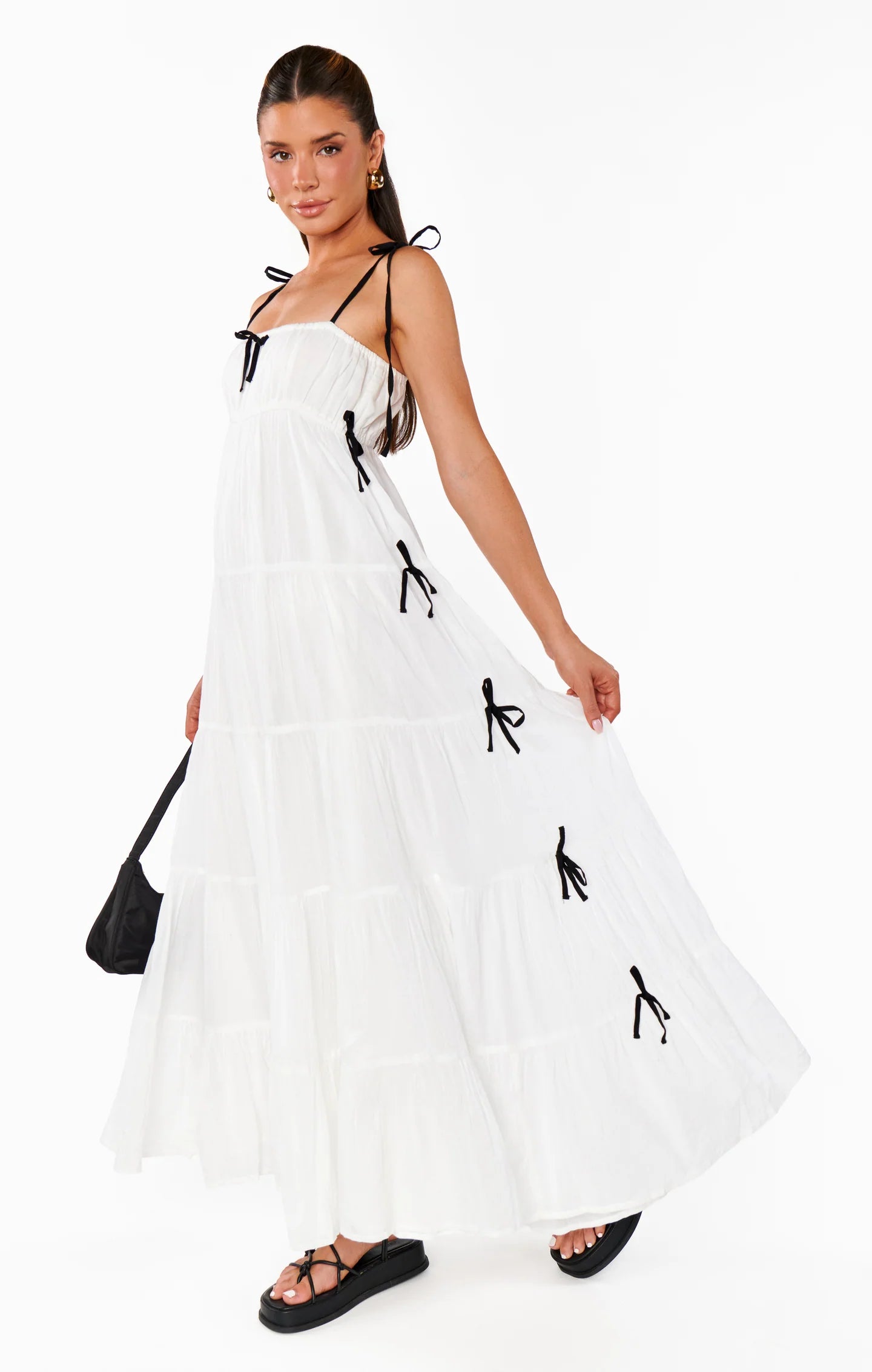 Woman wearing a white dress with black details on a white background