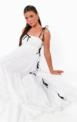 Woman wearing a white dress with black details on a white background