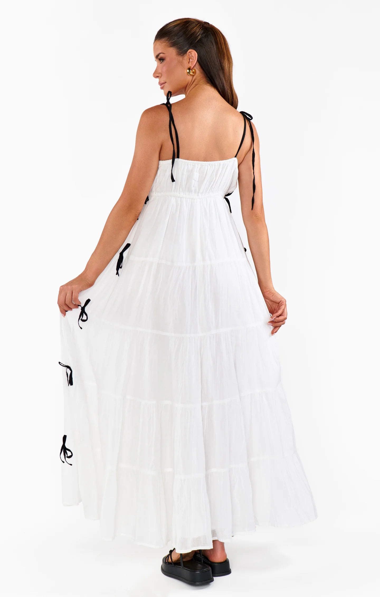 Woman wearing a white dress with black accents on a white background