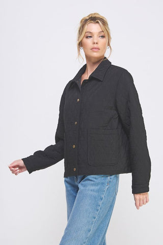 Woman wearing a black jacket and blue jeans on a white background