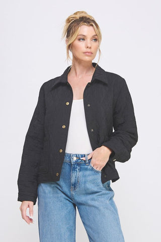 Woman wearing a black jacket and blue jeans on a white background