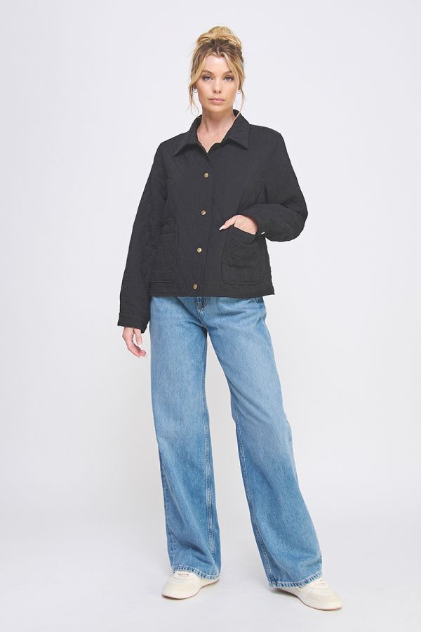 Woman wearing a black jacket and blue jeans on a white background