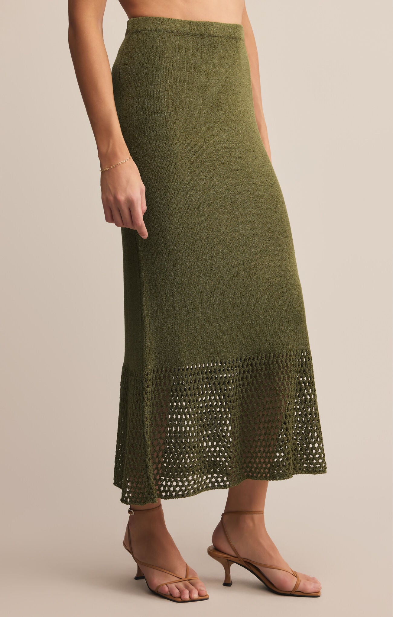 Olive green skirt with lace hem on a beige background