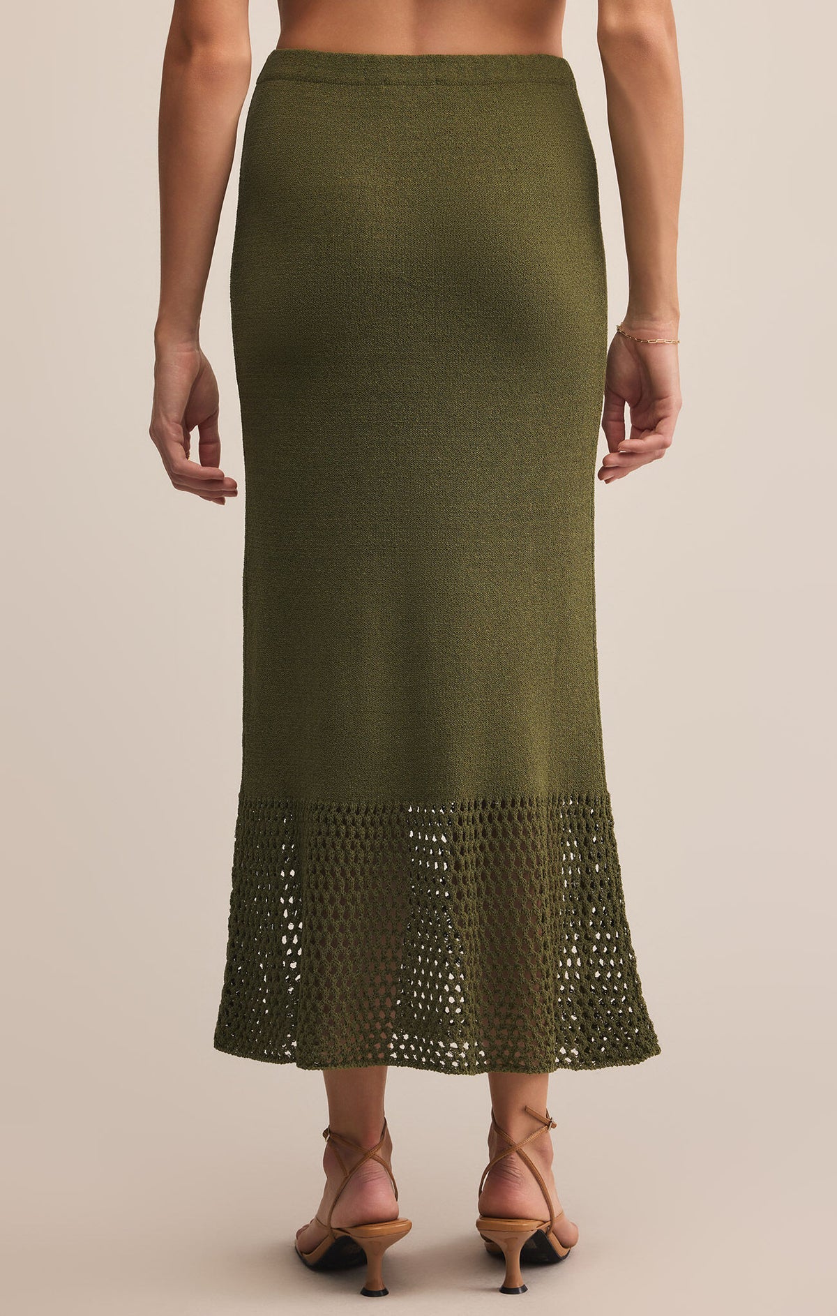 Green skirt with lace hem on a neutral background