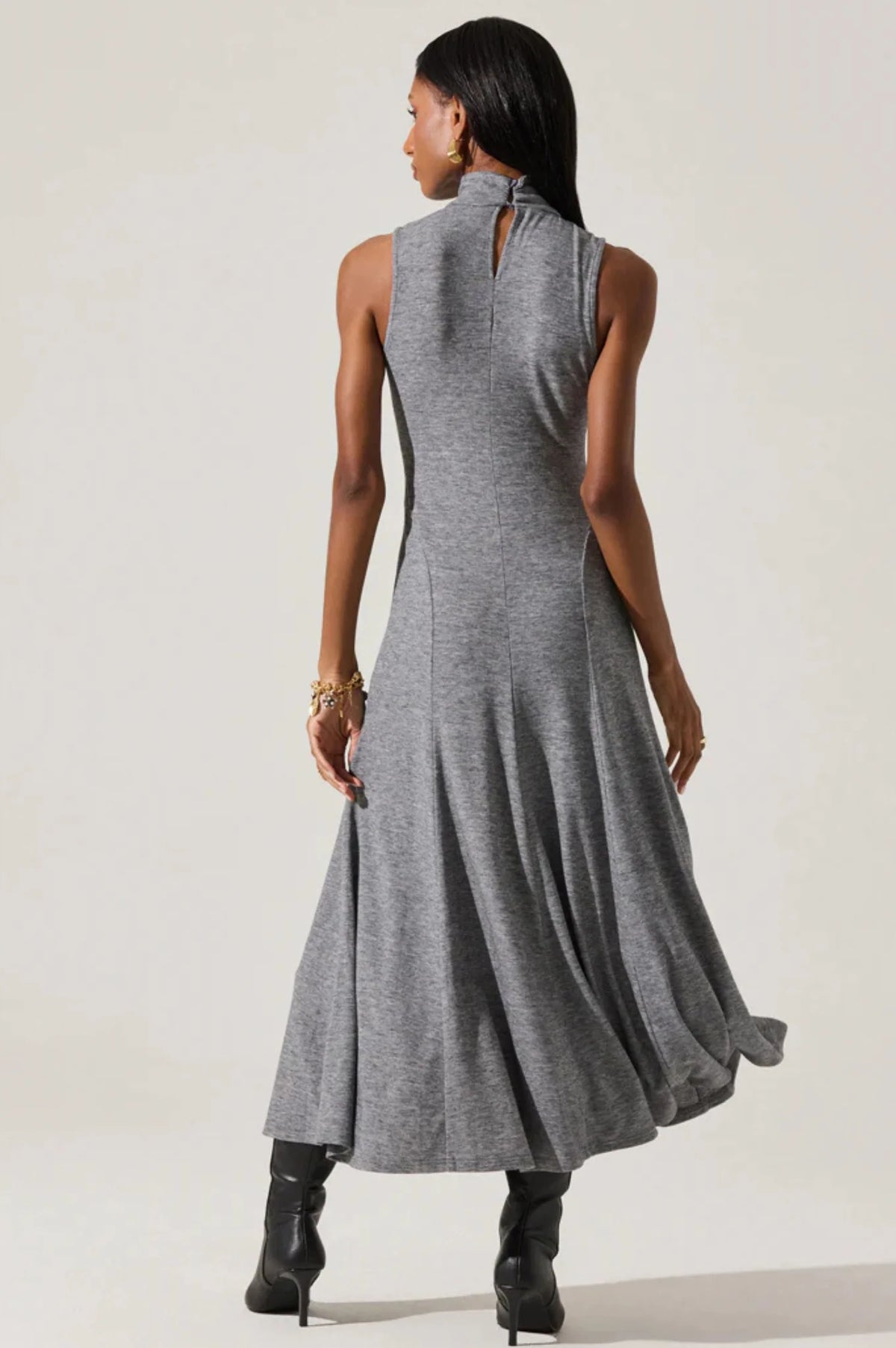 Woman wearing a gray sleeveless dress against a white background