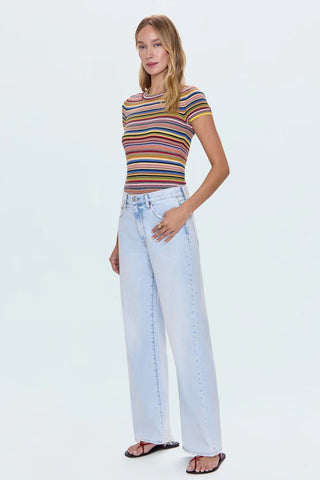 Woman wearing a striped shirt and light blue jeans on a white background