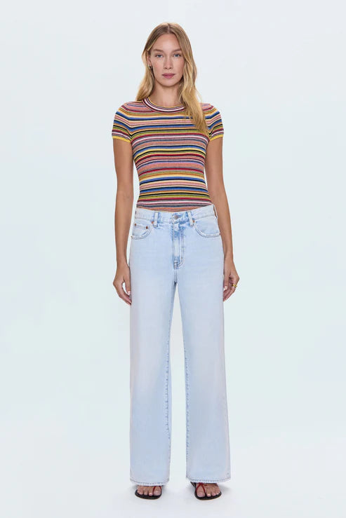Woman wearing a striped shirt and light blue jeans on a white background