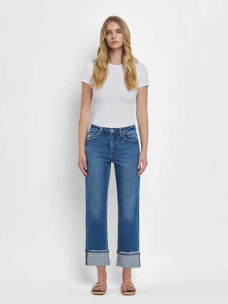 Woman wearing a white t-shirt and blue jeans on a white background