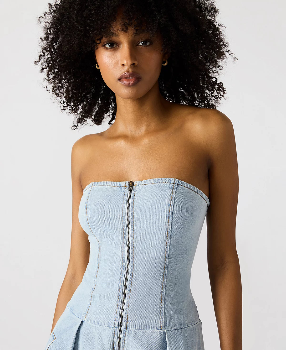 Woman wearing a light blue strapless dress on a white background