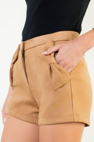 Tan shorts worn by a person on a plain background