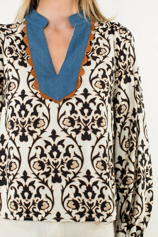 Patterned blouse with a blue neckline on a white background