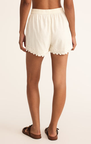 White lace-trimmed shorts worn by a person on a plain background