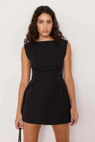 Woman wearing a black dress against a white background