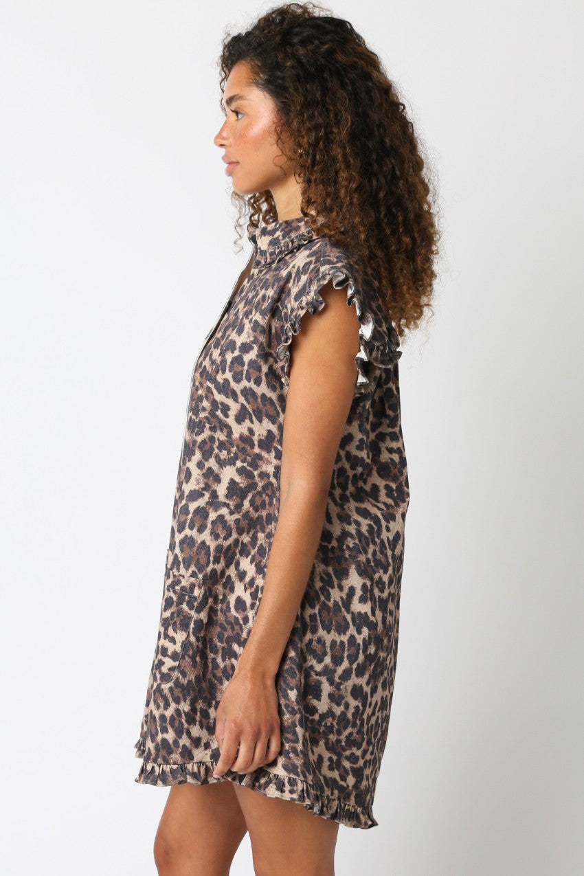 Woman wearing a leopard print dress against a plain background